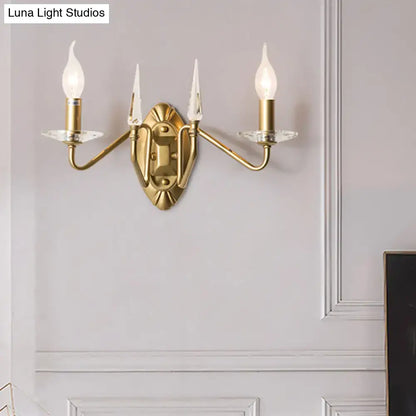Brass-finished iron candle wall light with three candle-style bulbs and crystal accents for living room decor