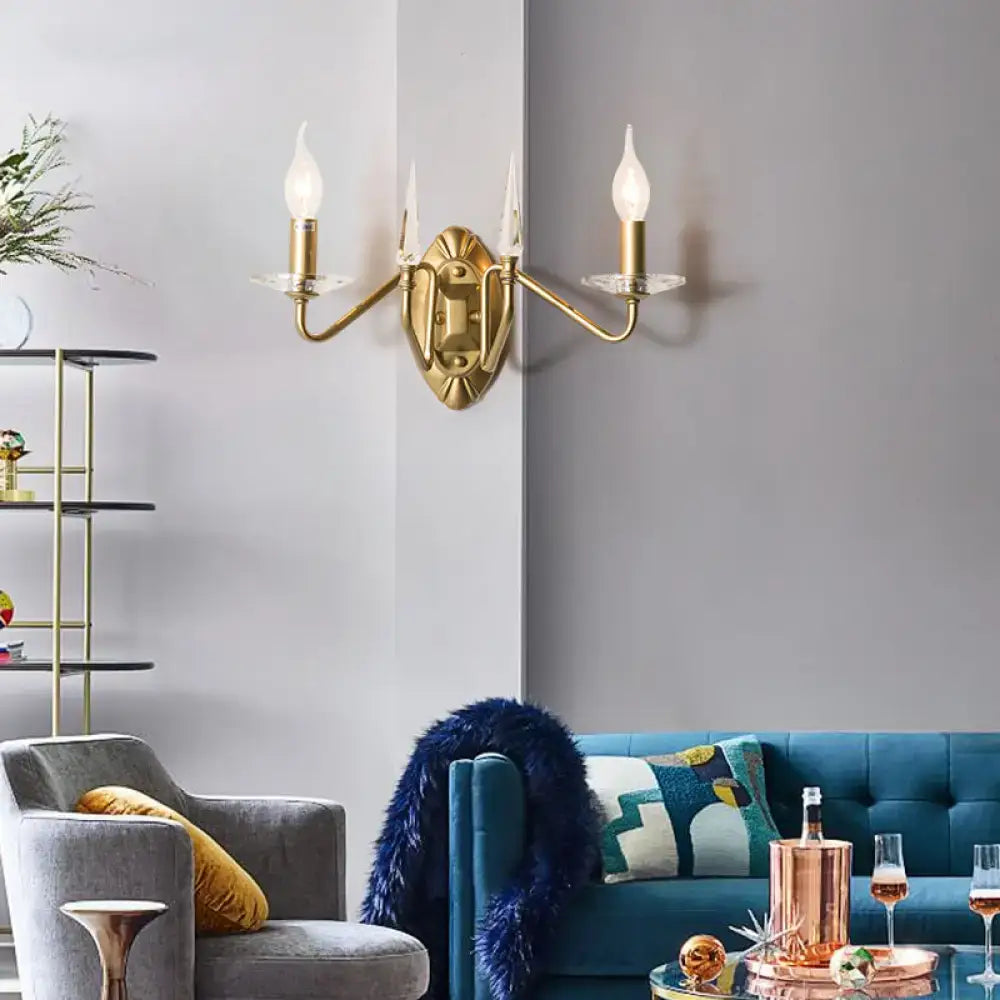 Modern gold iron candle wall light with two candle-style bulbs and clear glass shades for living room use