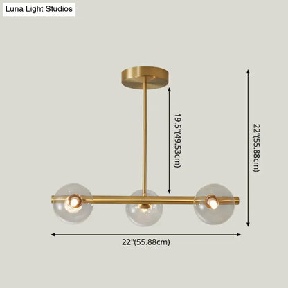 Brass-finished modern island pendant lighting with three clear glass globe shades for dining room illumination