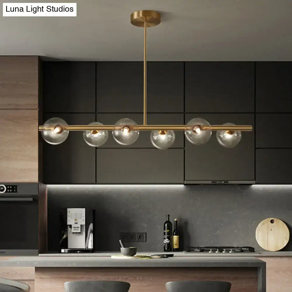 Modern gold island pendant lighting with five clear glass globe shades in brass for dining room pendant lighting