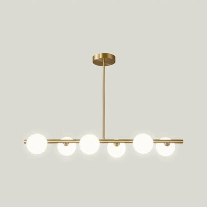 Modern gold island pendant lighting featuring five frosted glass globe shades in a linear island pendant design