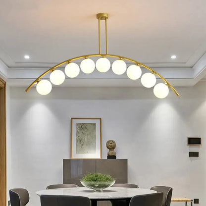Decorbites gold island pendant with clear white shade featuring gold-toned arch and spherical frosted glass bulbs
