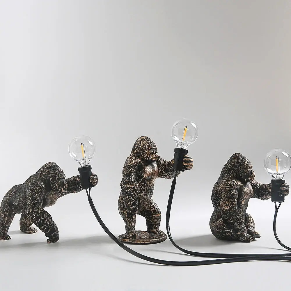 Modern gold king kong resin night light with three bronze-finished gorilla figurines holding edison-style bulbs by decorbites king kong