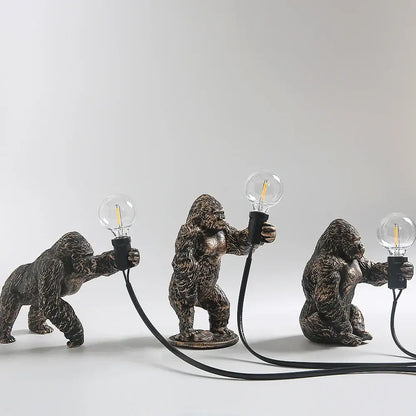 Modern gold king kong resin night light with three bronze-finished gorilla figurines holding edison-style bulbs by decorbites king kong