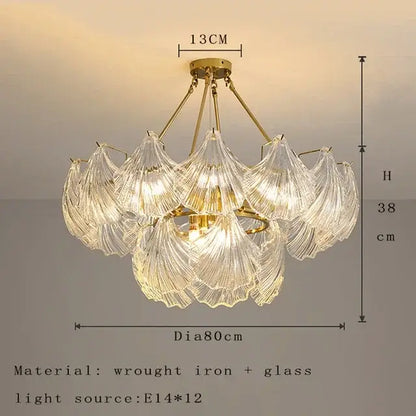 A delicate golden decorbites crystal glass chandelier with intricate leaf shades and wrought iron frame for dining room light