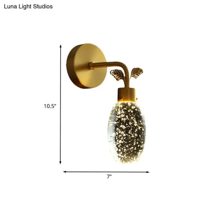 Modern gold leaf led wall sconce with seeded crystal globe featuring sparkling particles and leaf accents for bedroom use