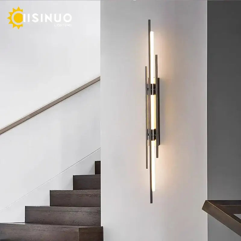 Modern gold led long liner wall sconce with sleek black metal rods and central glowing decorbites led long light bar