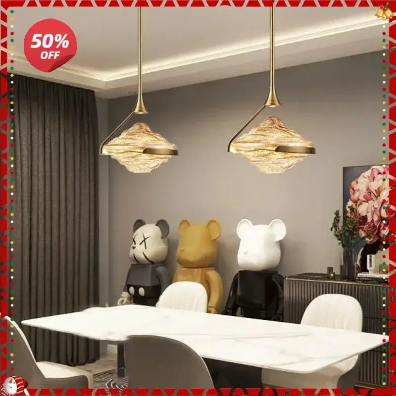 Two elegant gold led pendant lamps with textured cloud-like glass shades hang above a modern dining table