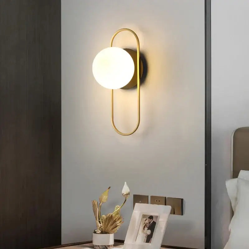Modern gold led wall lamp with frosted glass and sleek curved metal frame for living room illumination