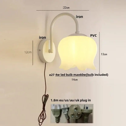 A soft yellow tulip-shaped led wall sconce with frosted glass and white iron base for modern stairway lighting