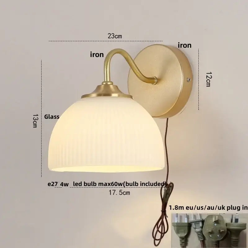 Vintage-style led wall sconce with brass iron frame and ribbed off-white glass shade for stairway lighting