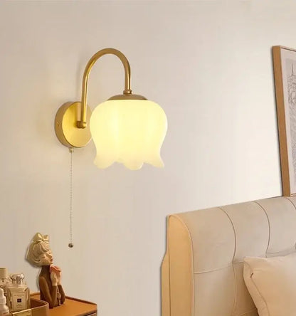 Modern gold led wall sconce with a frosted glass tulip-shaped shade for elegant stairway lighting