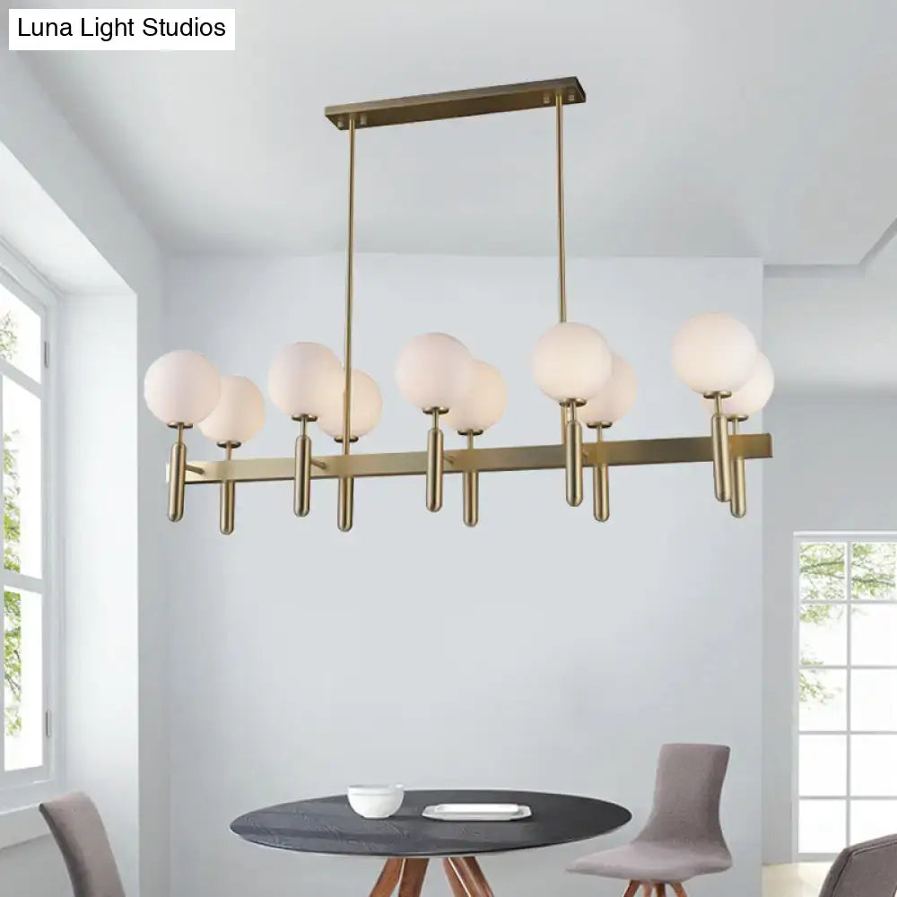 Modern brass-finished ceiling light fixture with gold linear design and white glass frosted globe shades