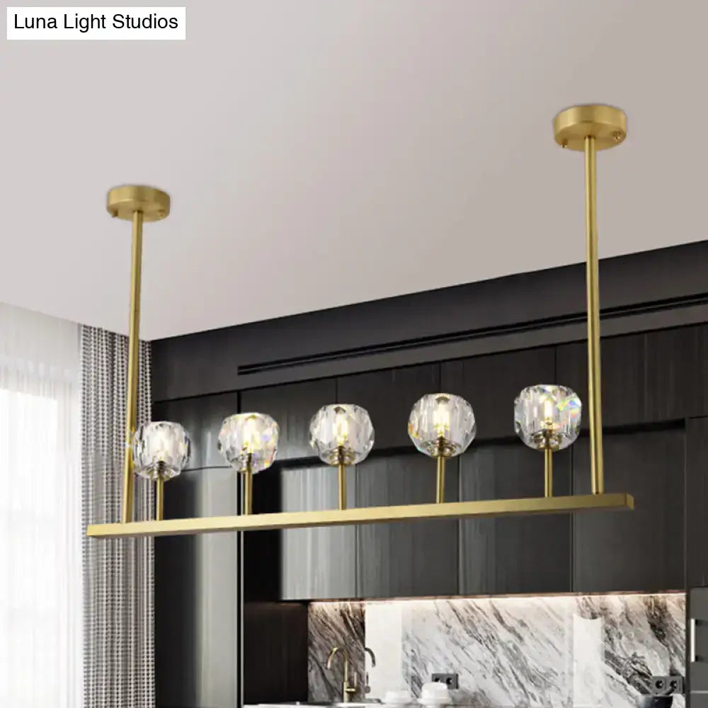 Gold-toned DecorBites™ 5-head linear crystal ball pendant light with faceted crystal globes for elegant dining rooms