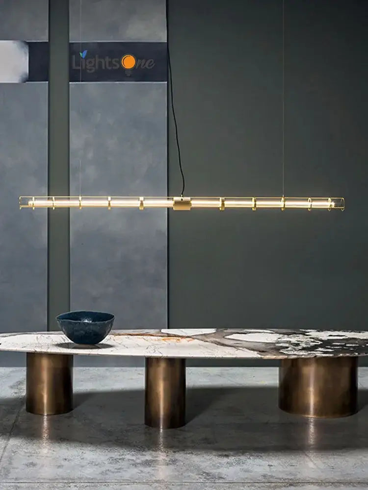Modern gold linear glass chandelier with sleek cylindrical segments and minimalist cables for dining room decorbites glass chandelier