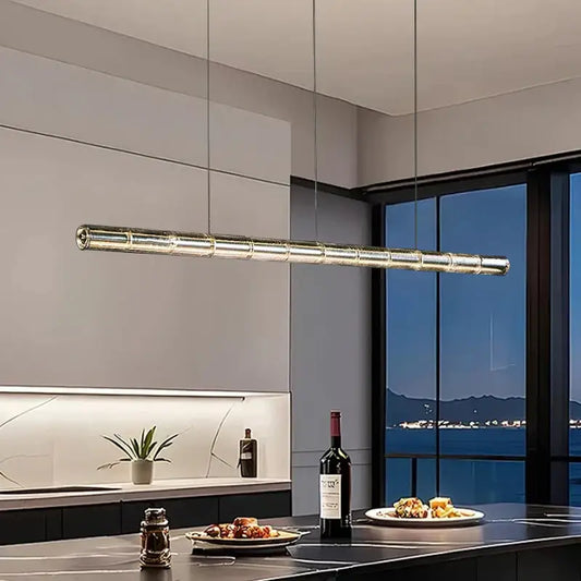 Modern gold linear glass led chandelier with segmented cylindrical design hanging above kitchen island lighting