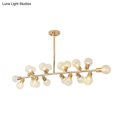 Modern gold linear island light with ribbing glass shade featuring frosted globe bulbs on a sleek metallic branch design