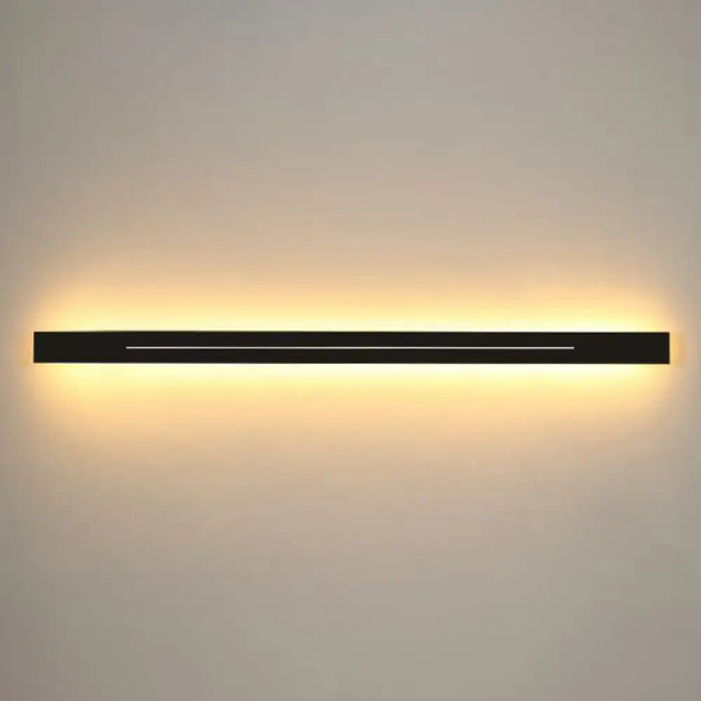 Modern gold linear led wall light fixture with black rectangular led wall light sconce emitting warm ambient light