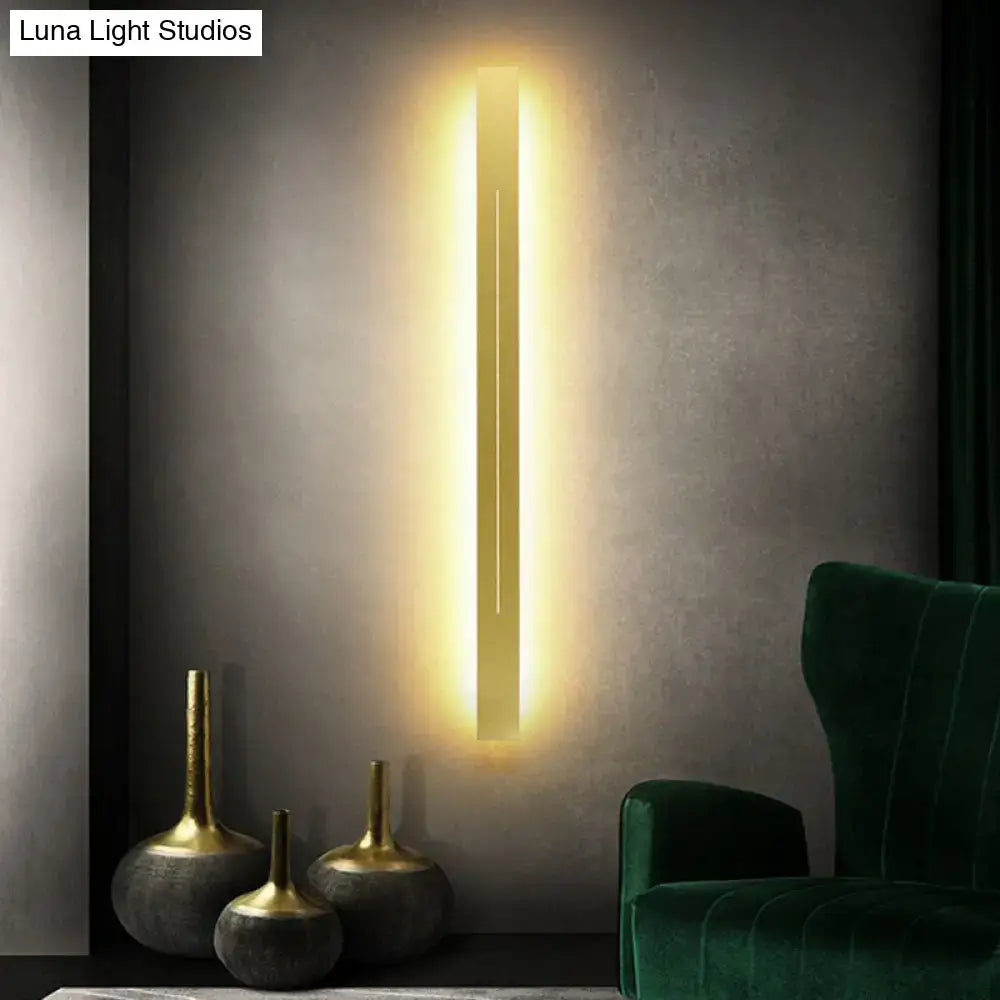 Modern gold linear led wall light fixture with a sleek minimalist design emitting warm ambient light for living room use