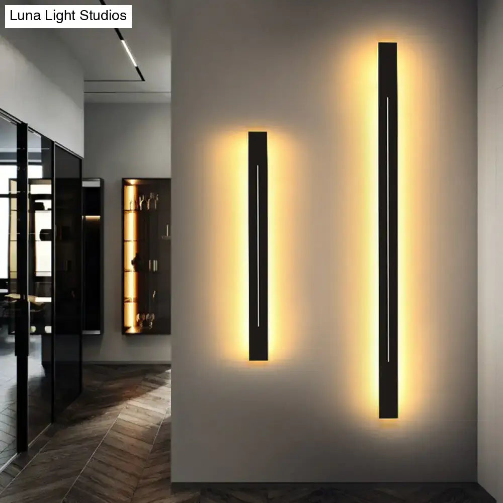 Two sleek black rectangular wall light fixtures with warm yellow backlighting for modern living room decor