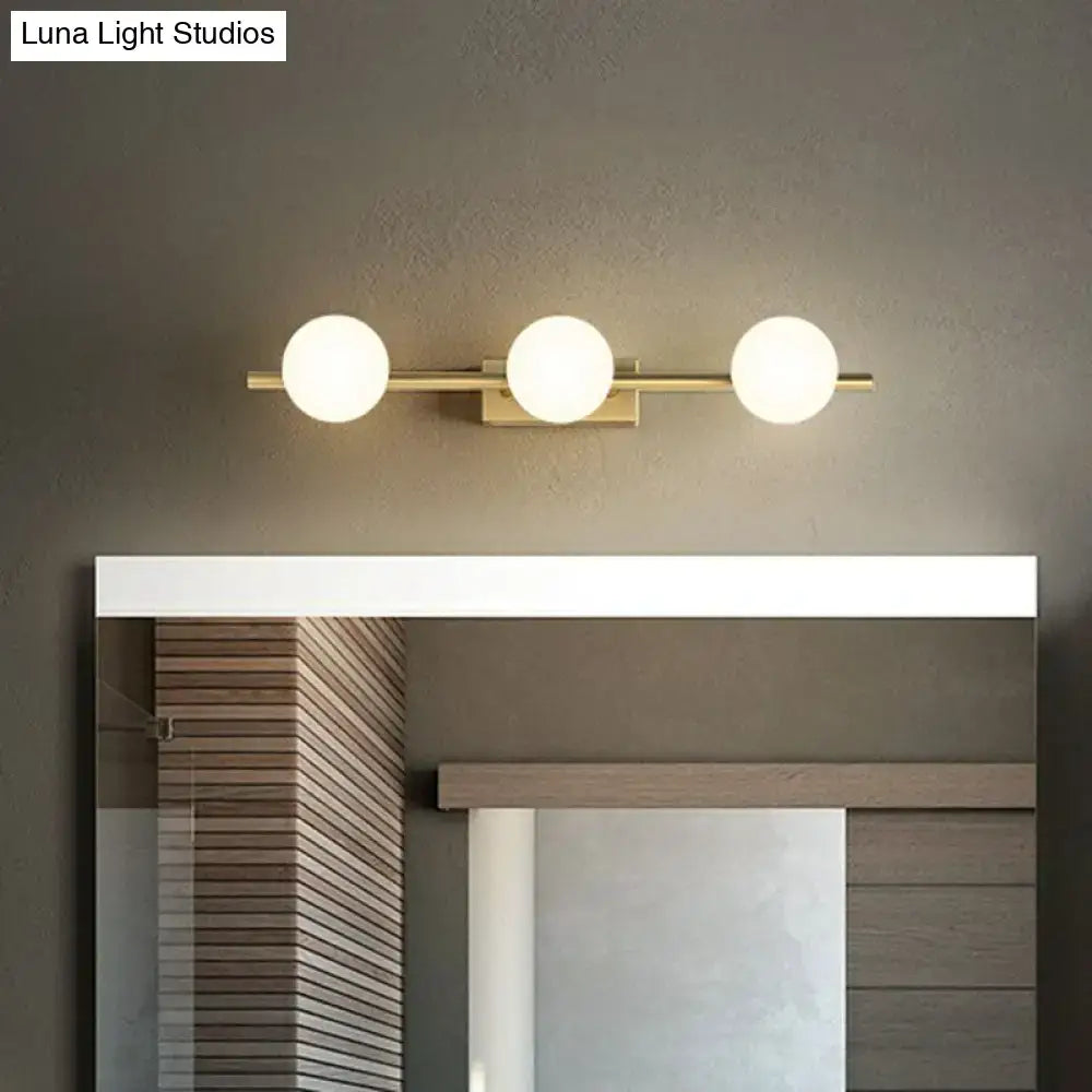 Modern gold linear wall sconce with three spherical milky ball glass bulbs for bathroom vanity lighting