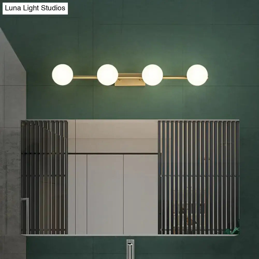 Modern gold linear wall sconce with sleek metal bar and four spherical milky ball glass bulbs for bathroom use