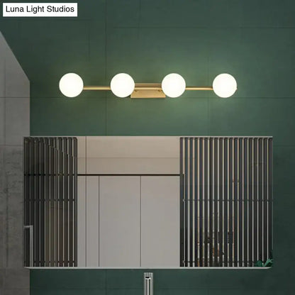Modern gold linear wall sconce with sleek metal bar and four spherical milky ball glass bulbs for bathroom use