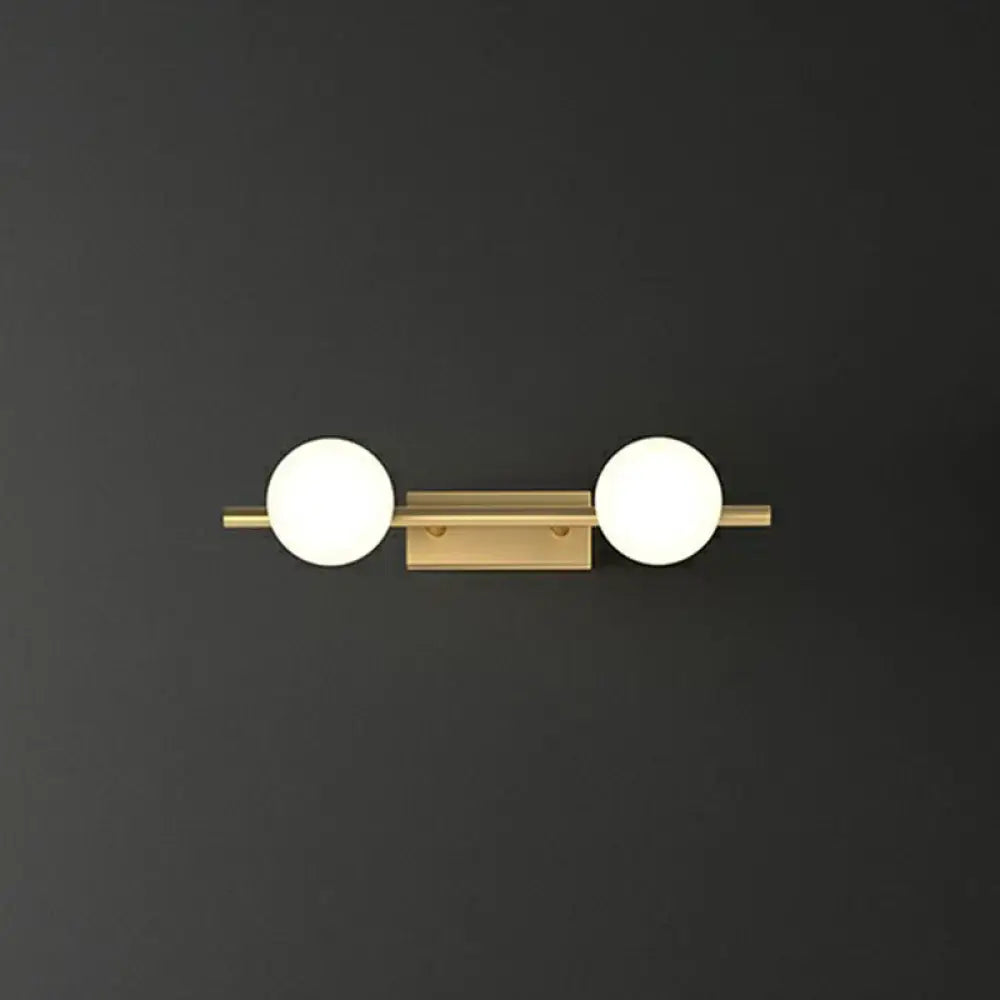 Modern gold linear wall sconce with two spherical milky ball glass globes for bathroom lighting