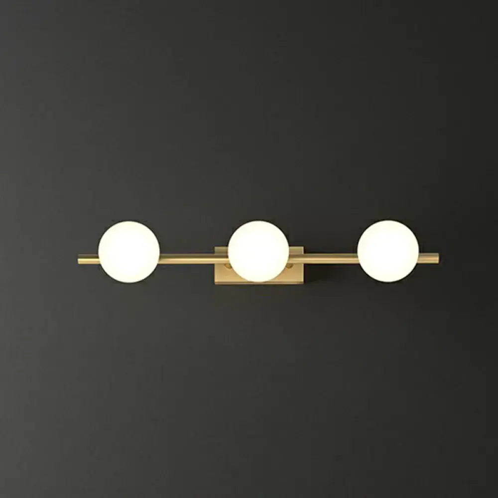 Modern gold linear wall sconce with three frosted milky ball glass globe bulbs for bathroom lighting