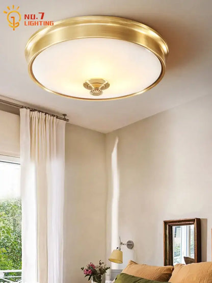 Modern gold lustre copper circular ceiling lamp with frosted glass diffuser and decorative central element for living room
