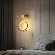 Modern gold luxury creative led bedside wall sconce with circular illuminated ring and curved arm design for bedroom use