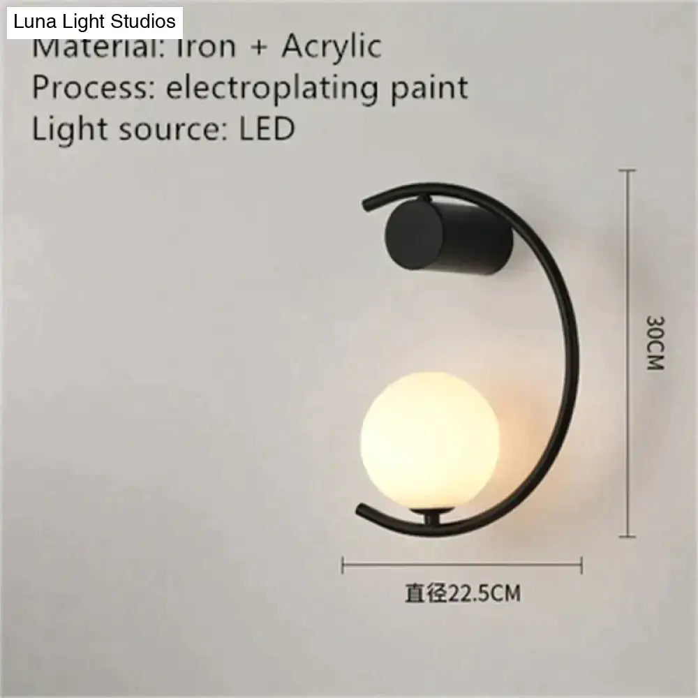 Black iron and acrylic led bedside wall sconce with curved arm and softly glowing spherical luxury creative led light