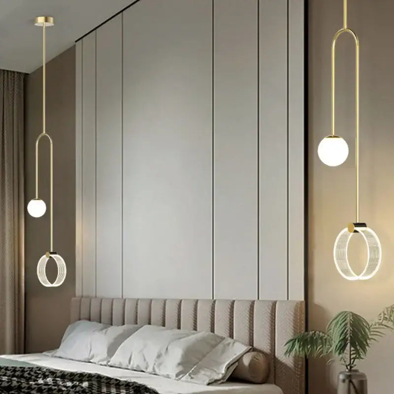 Modern gold luxury led pendant light with spherical and ring-shaped fixtures hanging elegantly above bed decorbites gold luxury