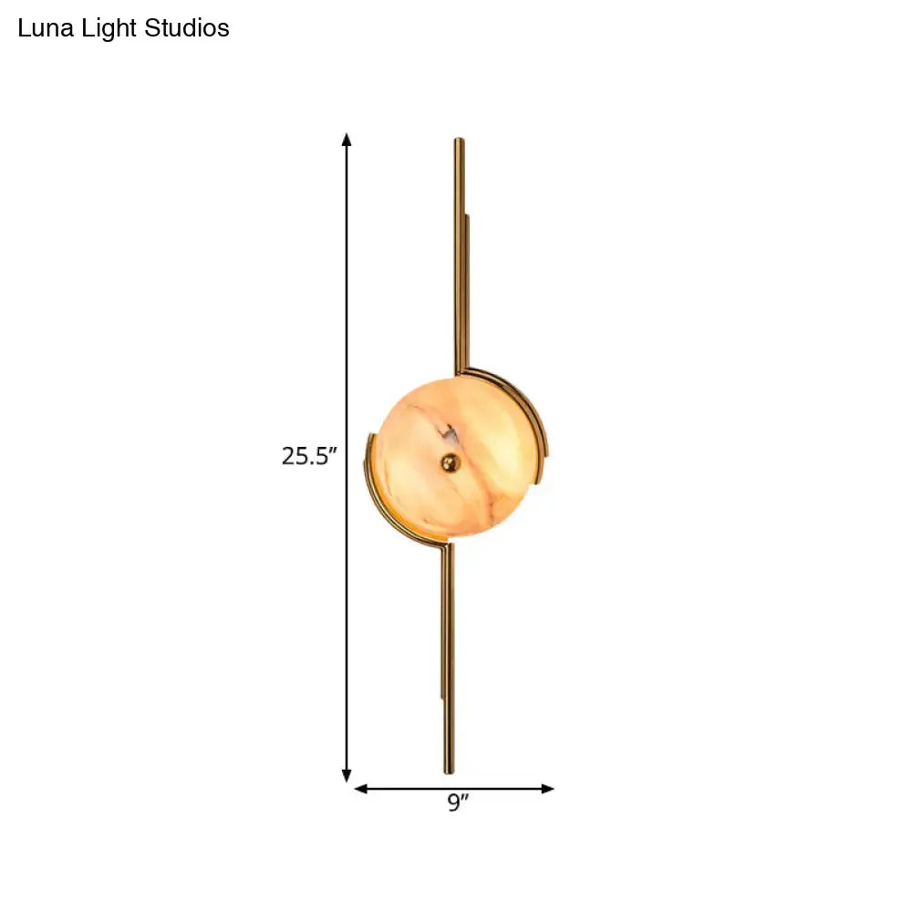 Modern gold marble led wall light featuring a warm amber marble disc and polished brass for bedroom use