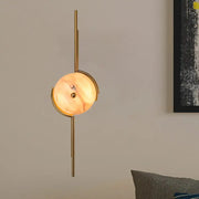 Modern gold marble led wall light featuring a gold-toned light fixture with a circular warm marble shade for bedroom use