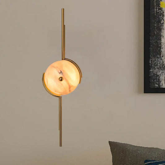 Modern gold marble led wall light featuring a gold-toned light fixture with a circular warm marble shade for bedroom use