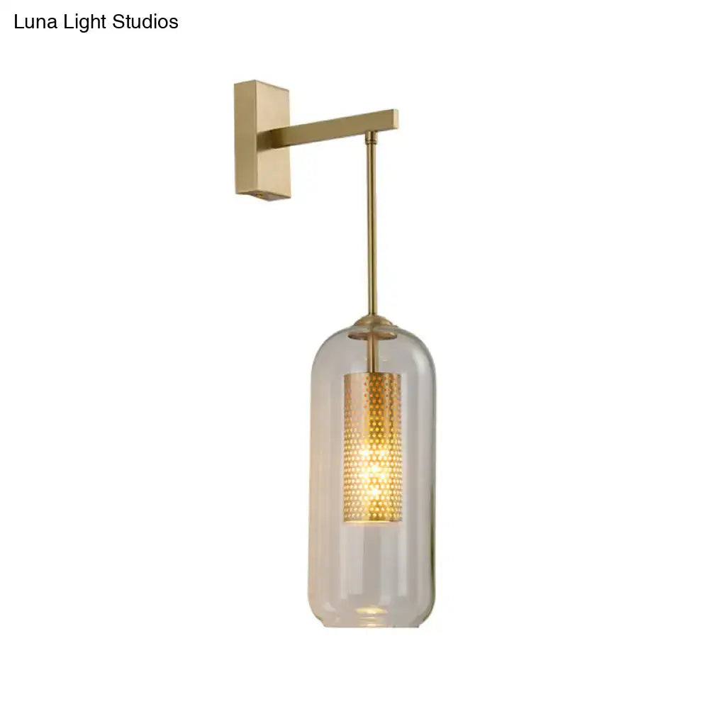Modern gold mesh and clear glass sconce with brass wall mount and illuminated perforated shade for bedroom lighting