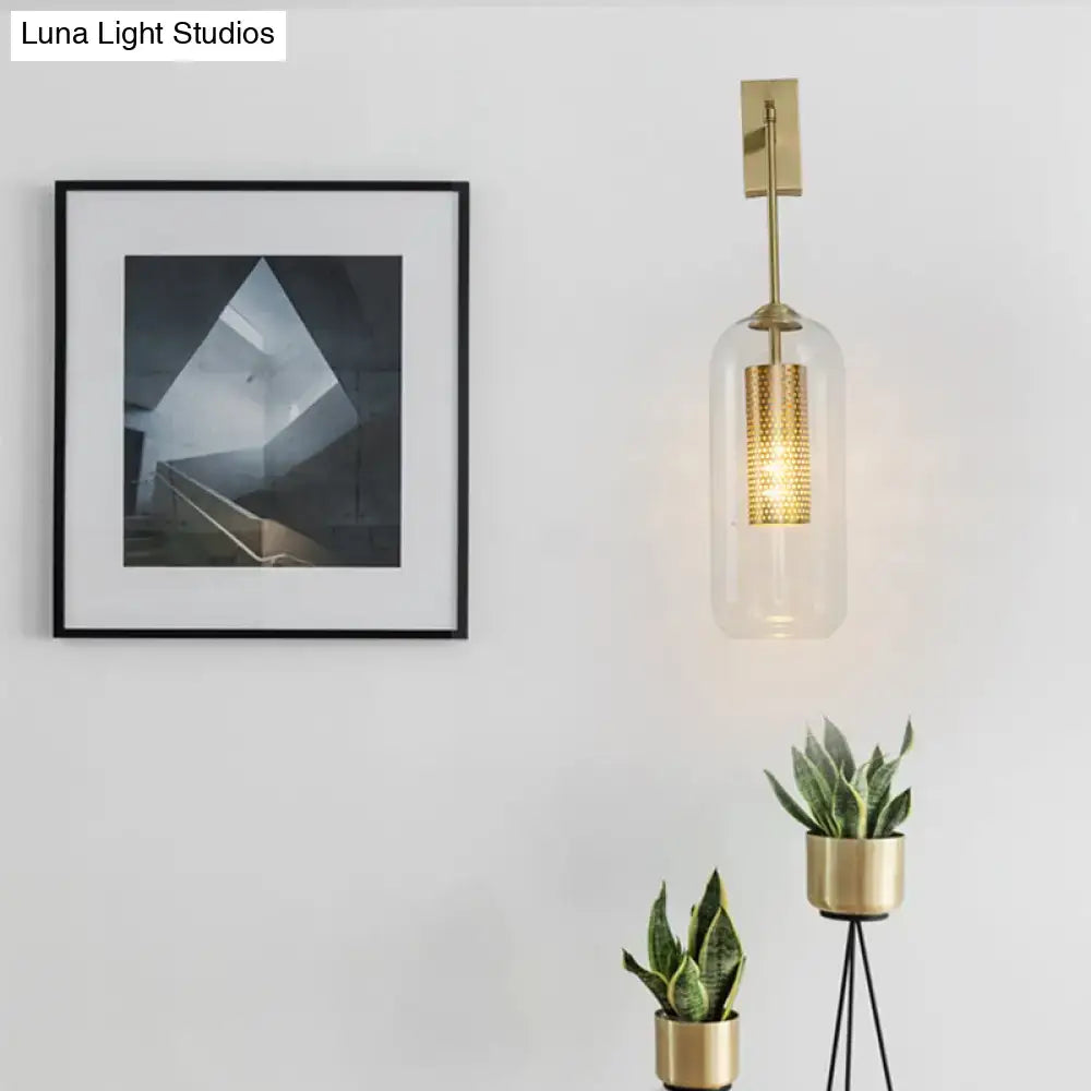 Modern gold mesh and clear glass sconce with illuminated perforated interior and gold-toned accents for bedroom wall lighting