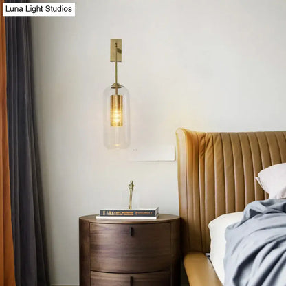 Modern gold mesh and clear glass sconce featuring a gold-toned wall lamp with a perforated metal shade for bedrooms