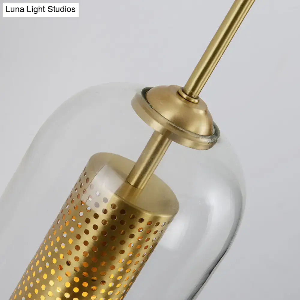 Modern gold mesh and clear glass sconce wall lamp featuring a gold-toned metal pendant with perforated cylindrical shade