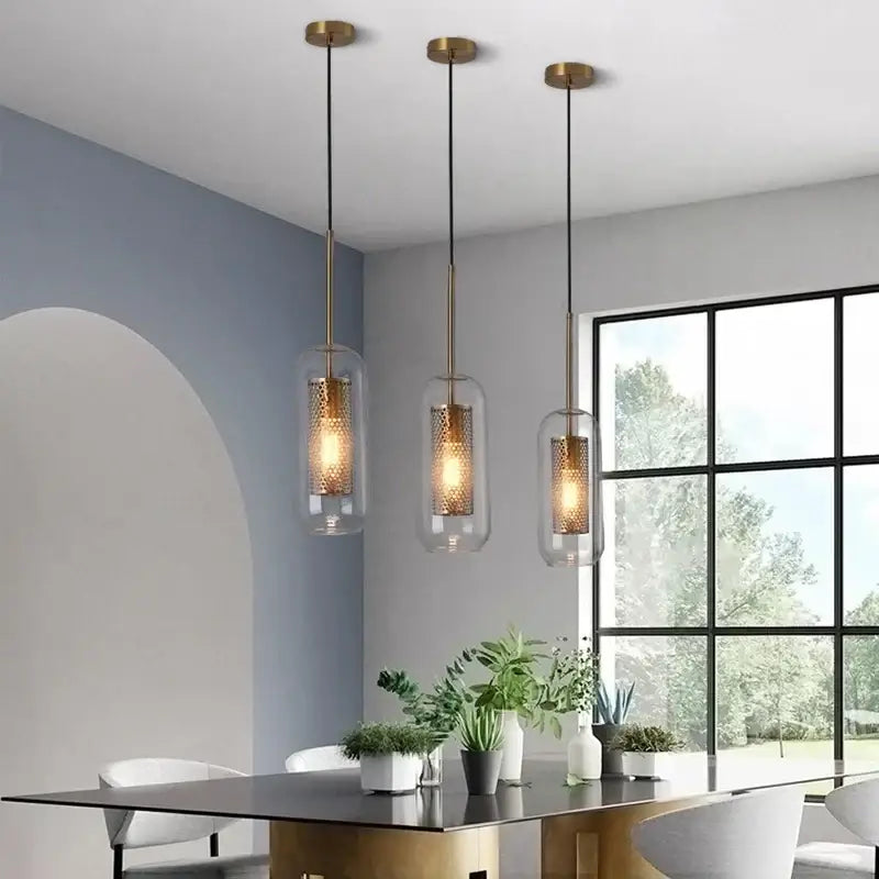 Three modern pendant lights with brass-finished decorbites gold mesh glass shades featuring a honeycomb pattern