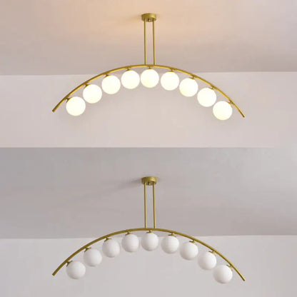 Modern gold metal arched ceiling light with ten frosted glass globe bulbs for dining room illumination