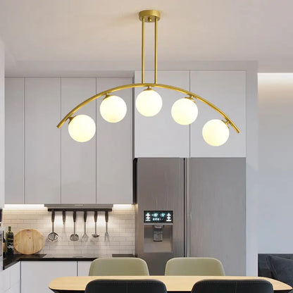 Modern gold metal arched ceiling light with five frosted glass globe bulbs for dining room use