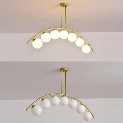 Modern gold metal arched ceiling light with six frosted glass globe bulbs for dining room illumination