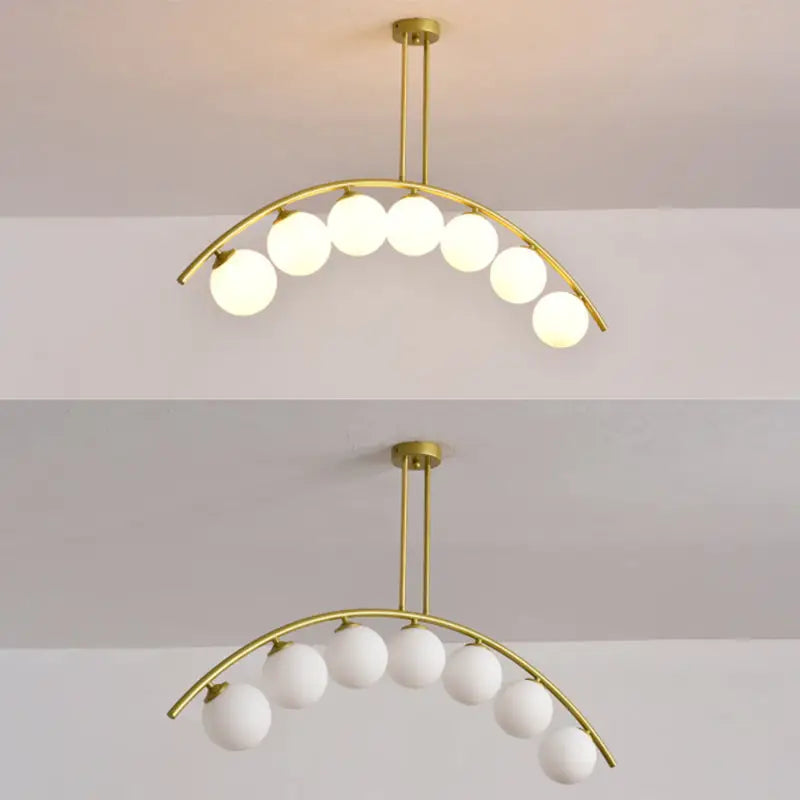 Modern gold metal arched ceiling light with six frosted glass globe bulbs for dining room illumination
