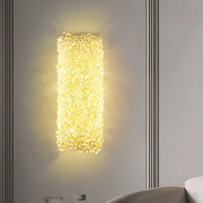 Modern gold metal crystal wall light with clear faceted beads emitting warm golden glow for bedroom sconce decorbites gold metal