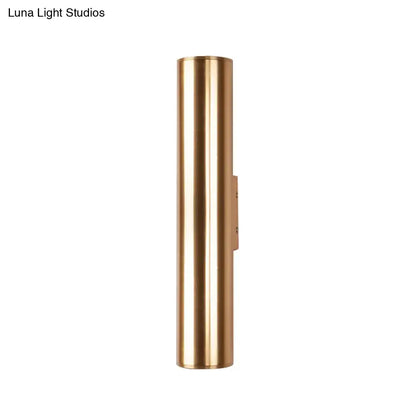 A sleek cylindrical brass wall lamp with a minimalist design and polished finish metal fixture for corridor use