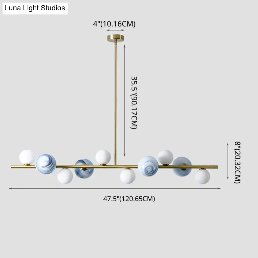 Modern gold metal pendant chandelier with white and blue marbled glass spheres and adjustable chain cord length for dining table