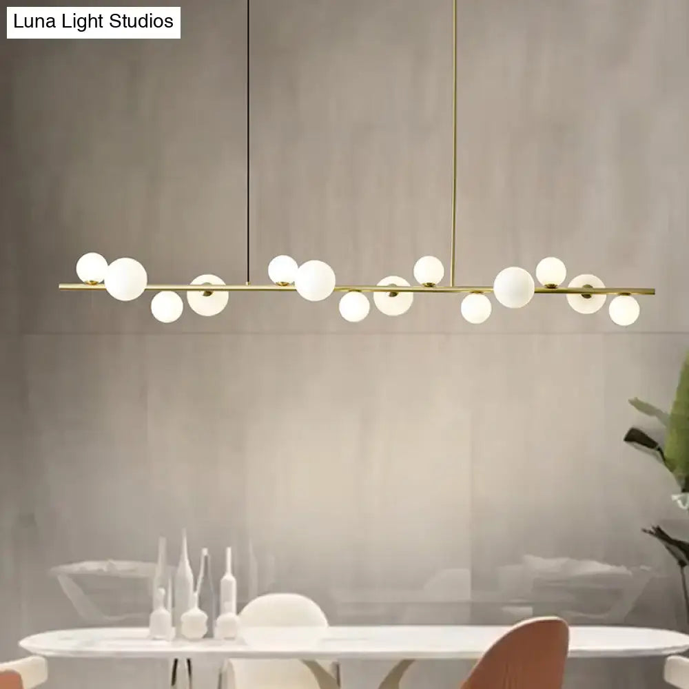 Modern gold metal pendant light with sleek horizontal bar and frosted glass globe bulbs for dining table with chain cord length