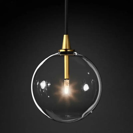 A modern gold metal globe pendant light with a brass fixture and black cord for dining room decorbites decor